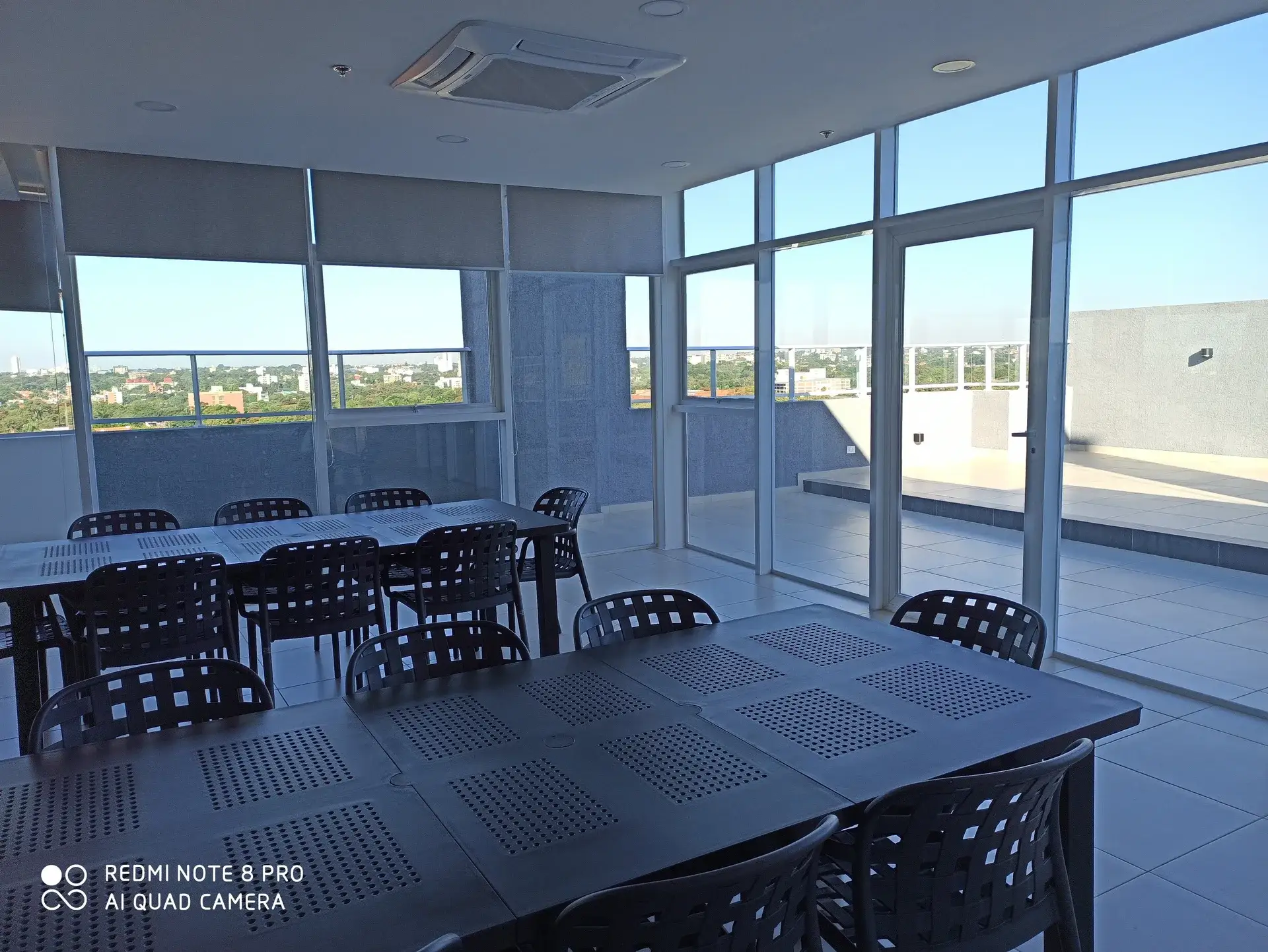 Cerramiento de vidrio con cortinas plegables en quincho de edificio